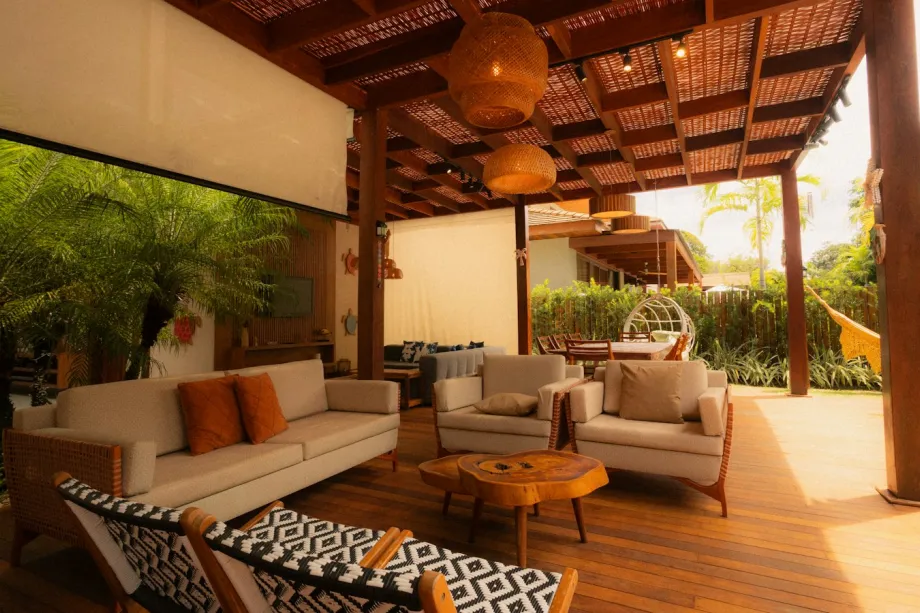 Covered outdoor living area with sofas and hanging chairs