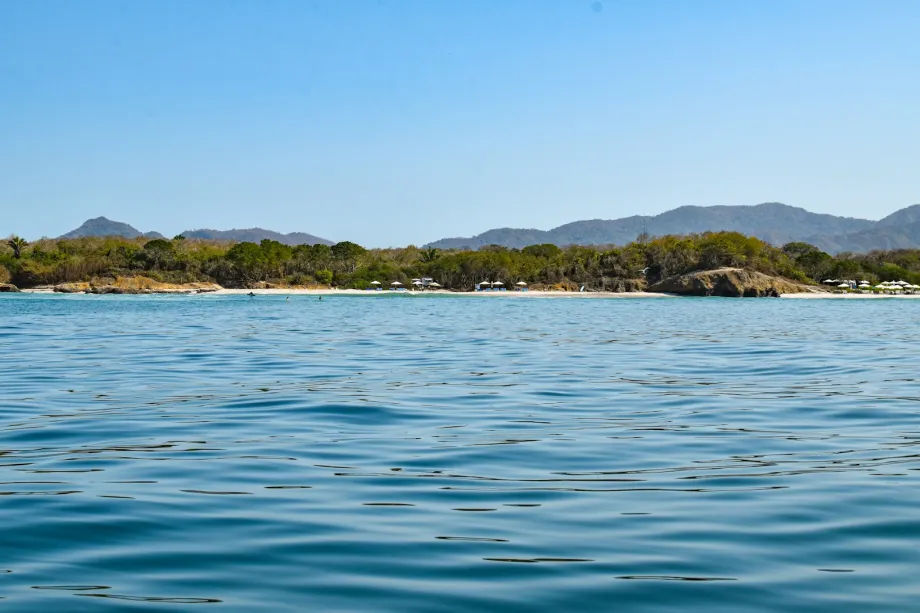 Calm bay with green mountains rising behind it